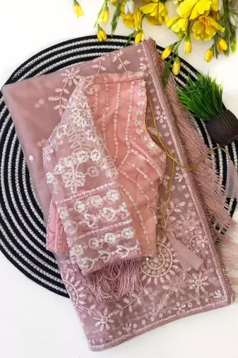 Pink embroidered net saree with feather-trimmed blouse and tassel detail