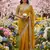 Yellow silk blend saree with scalloped zari border and striped blouse