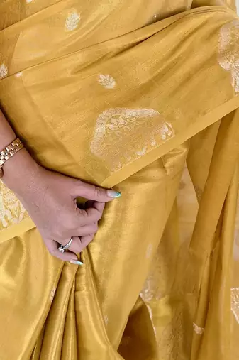 yellow tissue saree with zari elephant border design