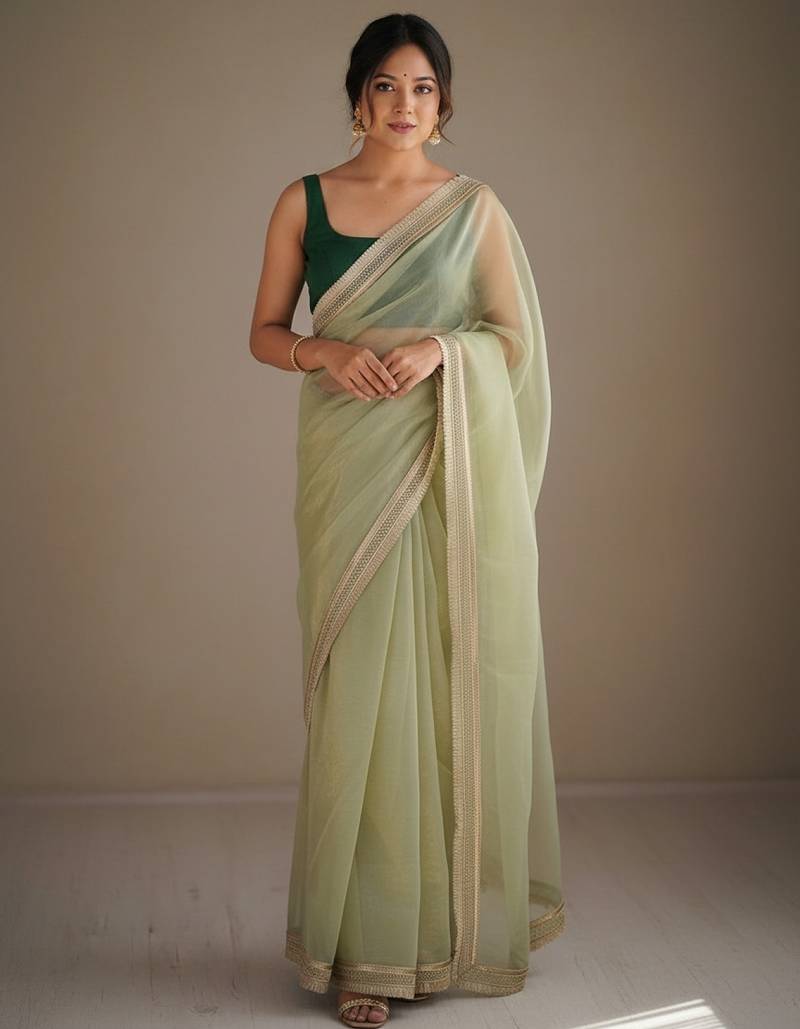 Lighte green net embellished saree with contrast blouse piece