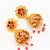  gold plated floral jhumka earrings with pink stone accents