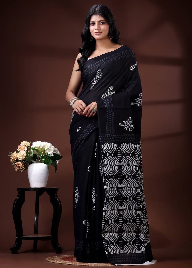 Jet black  malmal cotton saree with white floral butis and ornate geometric pallu