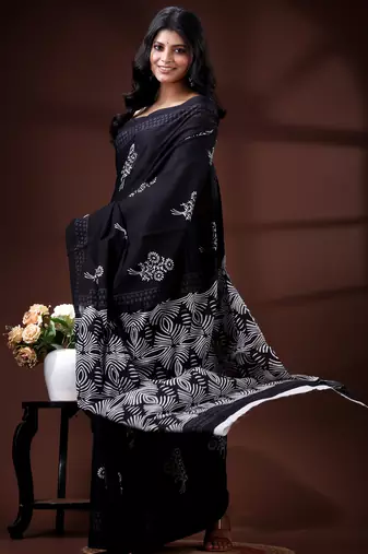 Jet black  malmal cotton saree with white floral butis and ornate geometric pallu