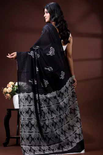Jet black  malmal cotton saree with white floral butis and ornate geometric pallu