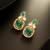 gold plated green stone and ad studded traditional drop earrings