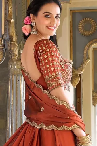 Rust orange Vichitra silk lehenga choli set featuring intricate sequins and thread embroidery