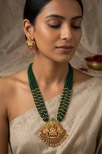 Women gold-plated & green multi-strand lakshmi temple jewellery set