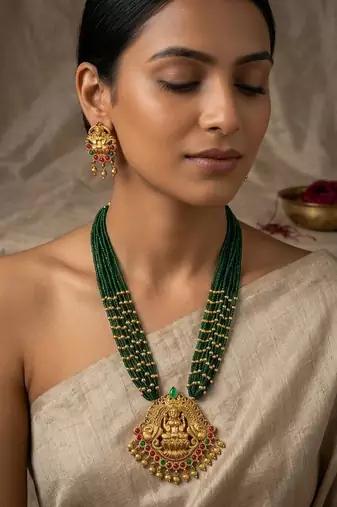 Women gold-plated & green multi-strand lakshmi temple jewellery set