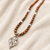 Brown and white pearl beaded necklace with silver geometric pendant, rhinestone accents, magnetic clasp