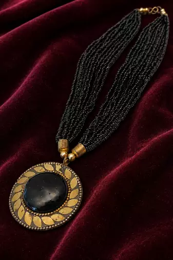 Black multi-strand beaded necklace with round gold leaf pendant, ethnic statement jewellery