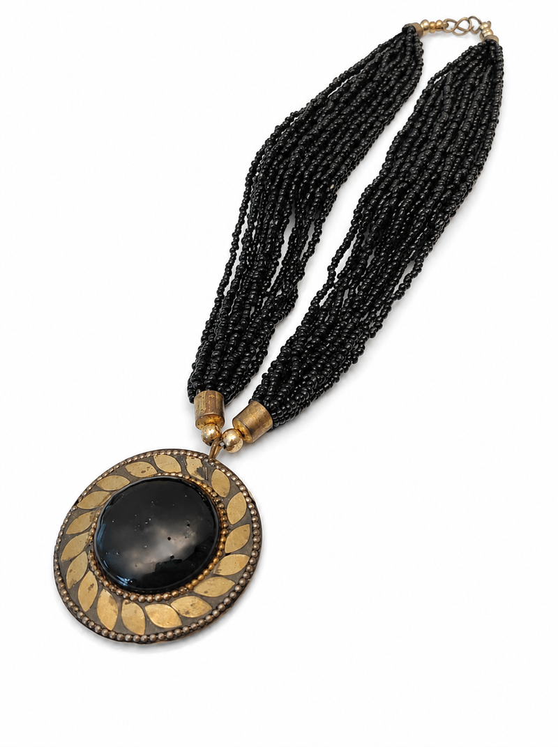 Black multi-strand beaded necklace with round gold leaf pendant, ethnic statement jewellery