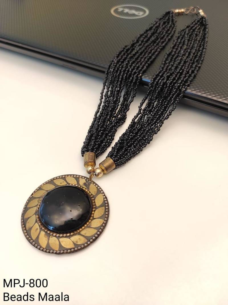 Black multi-strand beaded necklace with round gold leaf pendant, ethnic statement jewellery