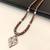 Brown and white pearl beaded necklace with silver geometric pendant, rhinestone accents, magnetic clasp