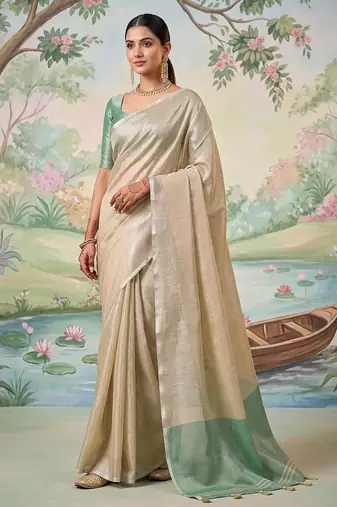 Beige colour tissue silk saree with silver grey pallu & tassels
