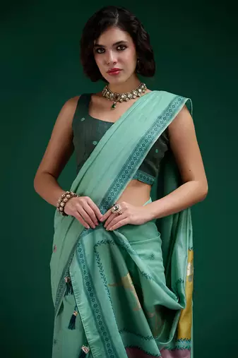 Turquoise handwoven saree with artistic floral patchwork pallu