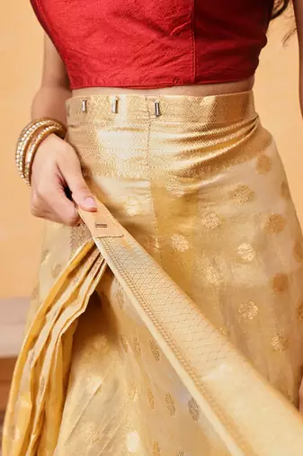Beige woven tissue party wear saree with blouse piece