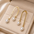 Gold-tone hammered arc drop earrings with freshwater pearl dangles, elegant stud style