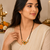 Traditional mangalsutra with double strand black beads, gold-toned kundan pendant, green stone