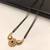 Traditional mangalsutra with double strand black beads, gold-toned kundan pendant, green stone
