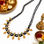 Traditional black beaded mangalsutra necklace, gold-toned, triple strand, lakshmi coin charms, green stone accents