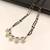 Double strand black bead mangalsutra with green & white cz floral pendant, gold-toned