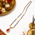 Gold-toned mangalsutra with ruby red teardrop pendant, black bead chain, cz stone accents