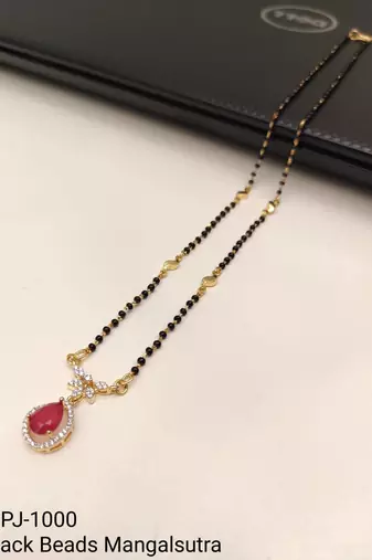 Gold-toned mangalsutra with ruby red teardrop pendant, black bead chain, cz stone accents