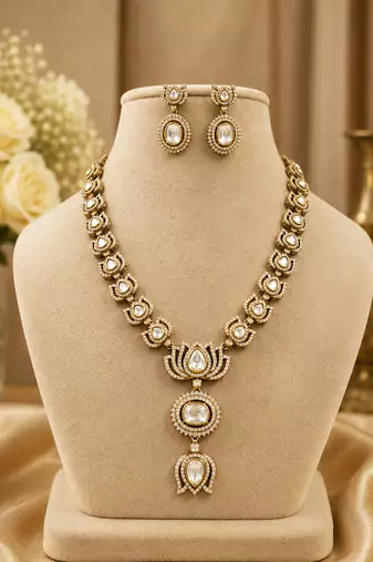 Elegant kundan-inspired gold-tone necklace set with statement pendant & matching earrings