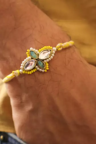 Yellow kundan floral pearl rakhi with roli chawal capsules