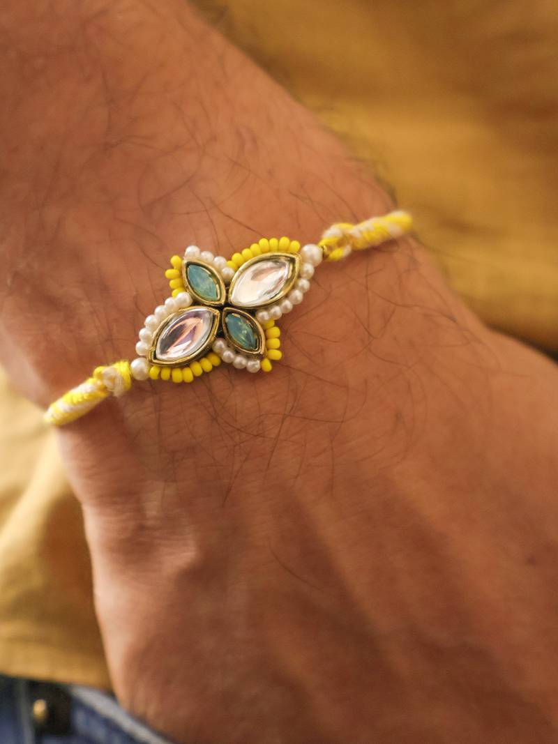 Yellow kundan floral pearl rakhi with roli chawal capsules