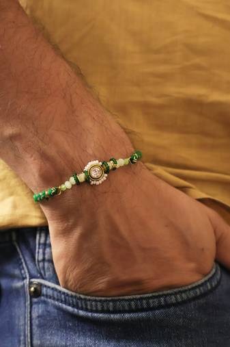 Green beaded floral charm rakhi with roli chawal capsules