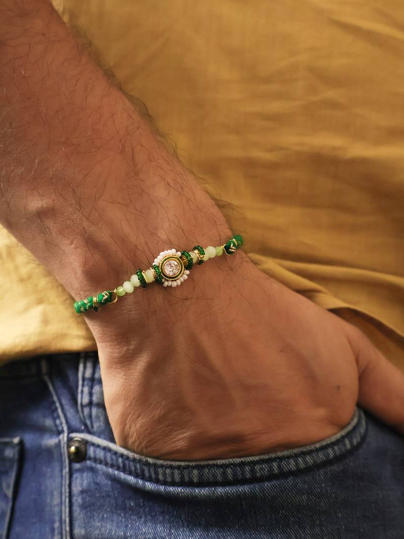Green beaded floral charm rakhi with roli chawal capsules