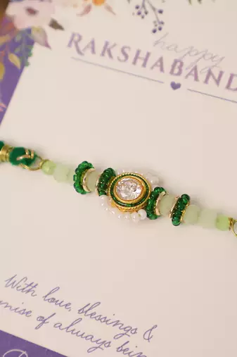Green beaded floral charm rakhi with roli chawal capsules