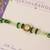 Green beaded floral charm rakhi with roli chawal capsules