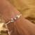 Purple floral pearl stone rakhi with roli chawal capsules