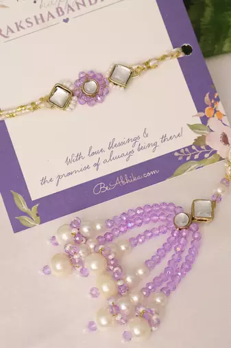 Purple floral pearl stone rakhi with roli chawal capsules