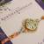 Pastel kundan pearl charm rakhi with roli chawal capsules