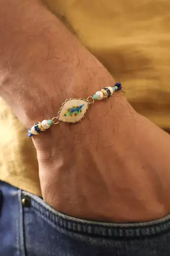 Blue peacock pearl charm rakhi with roli chawal capsules