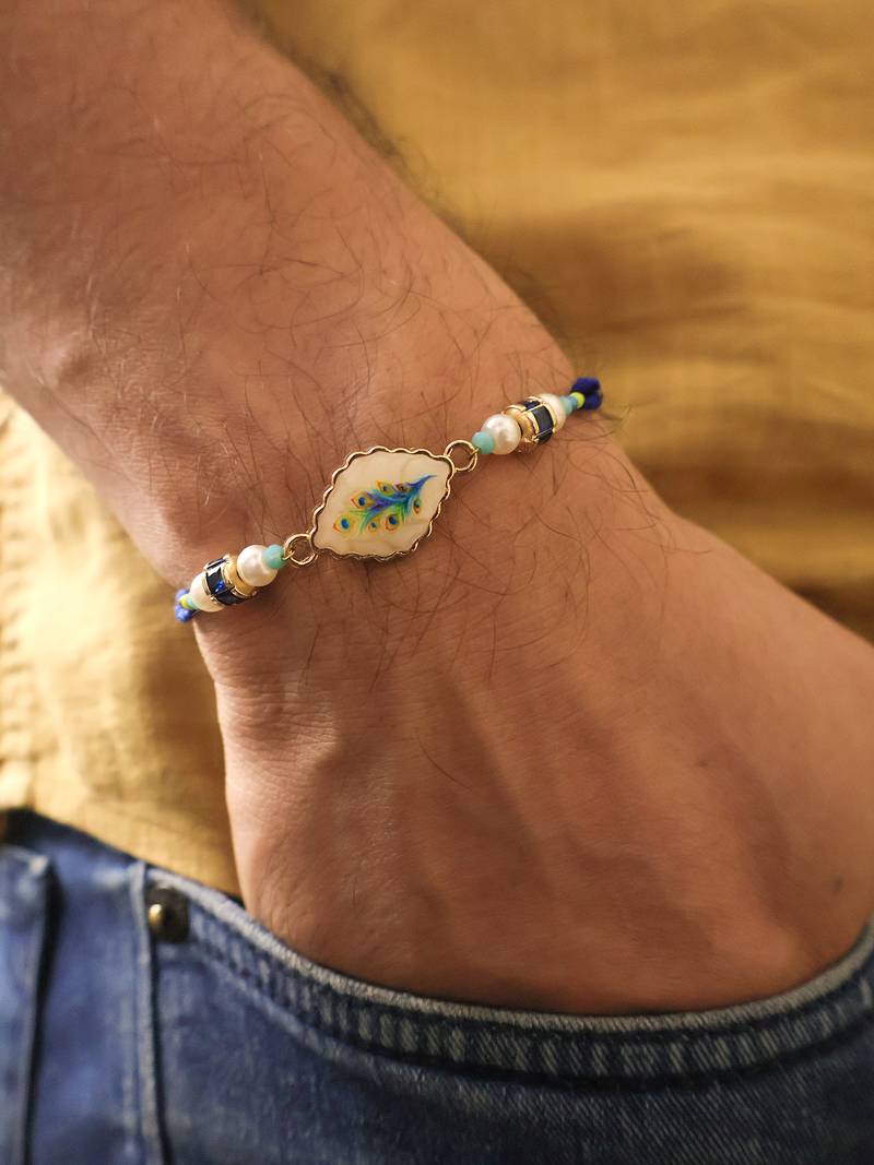 Blue peacock pearl charm rakhi with roli chawal capsules