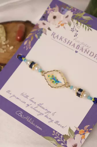 Blue peacock pearl charm rakhi with roli chawal capsules