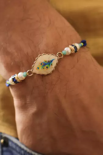 Blue peacock pearl charm rakhi with roli chawal capsules