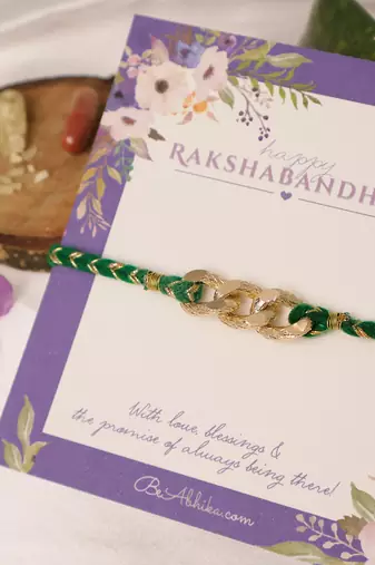 Golden chain green thread rakhi with roli chawal capsules