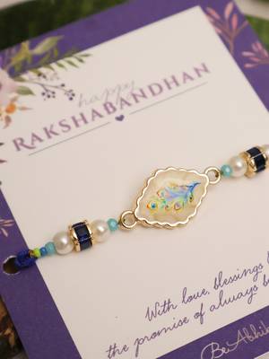 Blue peacock pearl charm rakhi with roli chawal capsules 4