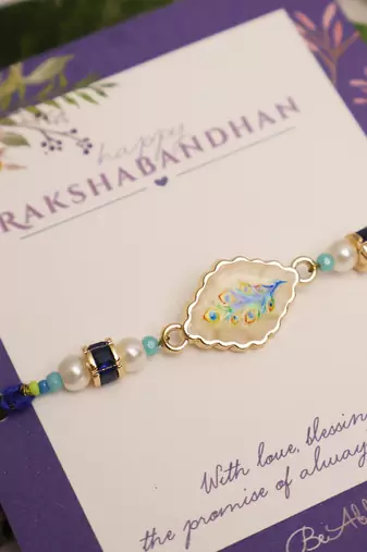Blue peacock pearl charm rakhi with roli chawal capsules