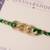 Golden chain green thread rakhi with roli chawal capsules