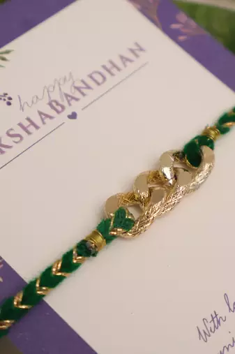 Golden chain green thread rakhi with roli chawal capsules