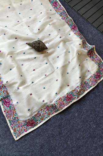 White tissue viscose saree features a heavy floral embroidered border and all-over buttis