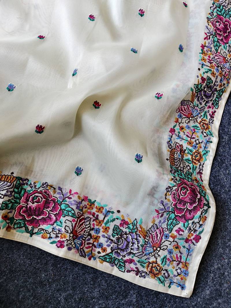 White tissue viscose saree features a heavy floral embroidered border and all-over buttis