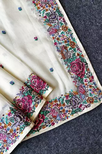 White tissue viscose saree features a heavy floral embroidered border and all-over buttis
