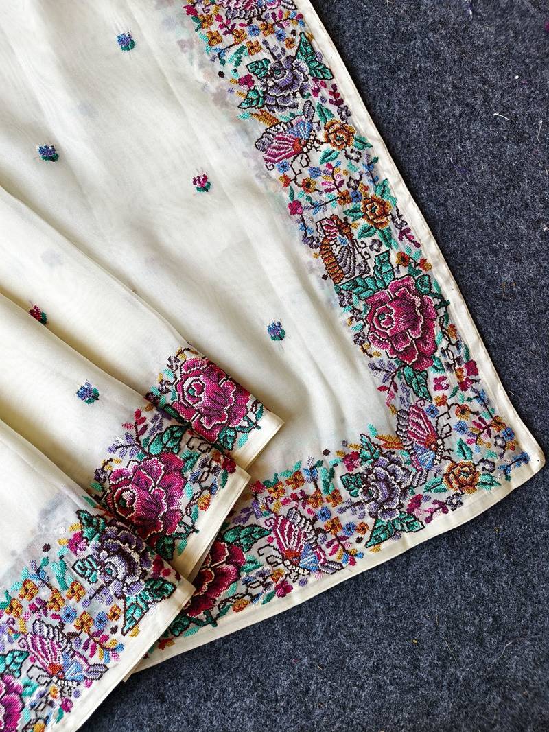 White tissue viscose saree features a heavy floral embroidered border and all-over buttis